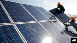 2011年8月22日工人在新疆哈密一個發電廠安裝太陽能板。
