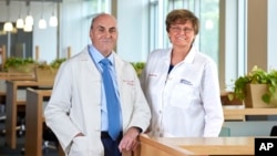 In this undated image provided by Penn Medicine, Katalin Karikó and Drew Weissman pose for a photo at the University of Pennsylvania in Philadelphia. (Peggy Peterson Photography/Penn Medicine via AP)