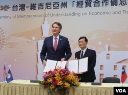 美國維吉尼亞州州長格倫·楊金(Glenn Youngkin)與台灣經濟部政次陳正祺於4月25日簽署“台灣–維吉尼亞州經貿合作備忘錄”。(美國之音特約記者李賢攝影)。