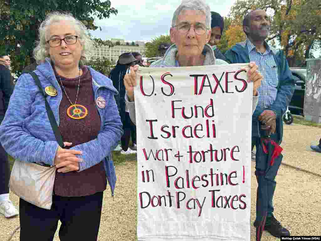 20 October 2023 - Washington'da Filistin'e destek mesajıyla düzenlenen eyleme katılan bir kişi "ABD vergileri İsrail savaşını ve Filistin'deki işkenceye fon sağlıyor" yazılı pankart taşıyor.