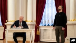 Američki predsednik Džo Bajden upisuje se u knjigu gostiju tokom susreta sa ukrajinskim predsednikom Volodimirom Zelenskim u Kijevu (Foto: AP/Evan Vucci, Pool)