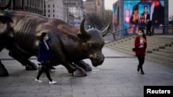 资料照：行人走过上海外滩金融牛旁。（2020年3月18日）