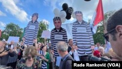 Kartonske lutke sa likom vlasnika Pinka, urednika Informera i predsednika Srbije, na šestom protestu protiv nasilja u Beogradu