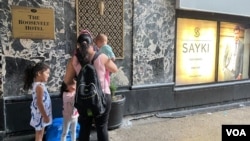 Una familia migrante puede verse en las afueras del hotel Roosevelt en Manhattan, convertido en refugio para recién llegados, el 18 de septiembre de 2023. 