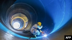 中国江苏连云港一家工厂的工人在焊接一个风井。（2023年5月31日）