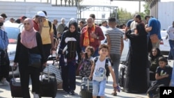 Los palestinos esperan en el cruce fronterizo de Rafah entre la Franja de Gaza y la Franja de Gaza de Egipto el sábado 14 de octubre de 2023. Israel llevó a cabo algunas operaciones terrestres limitadas antes de una ofensiva terrestre más amplia (Foto AP/Hatem Ali)