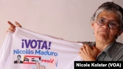 Yajaira Daboin, de 57 años, sostiene una franela con propaganda a favor del Maduro, que quiere proyectarse a 18 años en el poder