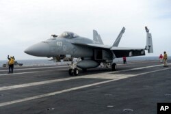 Sebuah F-18E parkir di dek penerbangan kapal induk USS Theodore Roosevelt, Kamis, 11 April 2024 selama latihan angkatan laut gabungan selama tiga hari oleh A.S., Jepang dan Korea Selatan di Laut Cina Timur. (AP/Mari Yamaguchi)