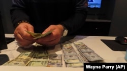 Frank Kaltađirone, uposlenik kladionice u "Ocean Casino Resortu" u Atlantik sitiju, broji novac koji su igrači uložili na njegovom radnom mjestu, 6. februara 2023. godine.