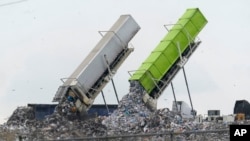 In this file photo, garbage is loaded into a landfill in Lenox Township, Mich., July 28, 2022. (AP Photo/Paul Sancya, File)