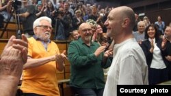 ARHIVA - Novinar nedeljnika "Radar" Vuk Cvijić pozdravlja prisutne koji mu aplaudiraju na tribini posvećenoj napadu na njega, u sklopu serijala "Nije filozofski ćutati", u Beogradu, 31. maja 2024. (Foto: FoNet)