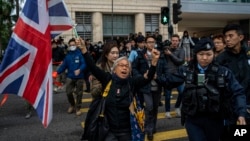 Activist Alexandra Wong, also known as Grandma Wong, holds a flag of Britain outside West Kowloon Magistrates' Courts, where activist publisher Jimmy Lai's trial is scheduled to open, in Hong Kong, Monday, Dec. 18, 2023. (AP Photo/Vernon Yuen)