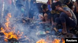 Palestinezët kërkojnë ushqim në mes rrënojave të djegura nga sulmi izraelit në një pjesë të Rafahut që shërbente për strehimin e të zhvendosurve më 27 maj, 2024/Reuters