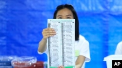 A Thai officer shows a ballot during vote counting at polling station in Bangkok, Thailand, May 14, 2023. 