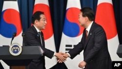 រូបឯកសារ៖ ប្រធានាធិបតីកូរ៉េខាងត្បូង Yoon Suk Yeol និងនាយករដ្ឋមន្ត្រីជប៉ុនលោក Fumio Kishida ចាប់ដៃគ្នា នៅក្នុងអំឡុងសន្និសីទសារព័ត៌មានមយយ នៅទីក្រុងសេអ៊ូល ប្រទេសកូរ៉េខាងត្បូង កាលពីថ្ងៃទី ៧ ខែឧសភា ឆ្នាំ ២០២៣។ 