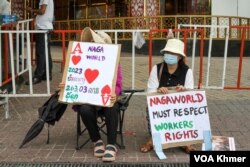 កូដករពីរនាក់អង្គុយលើកបដាតវ៉ា នៅពីមុខក្រុមហ៊ុន ណាហ្គាវើល៍ ក្នុងរាជធានីភ្នំពេញ នាថ្ងៃទី ៣១ ខែសីហា ឆ្នាំ២០២៣។ (ស៊ឹម ចាន់សំណាង/វីអួអេ)