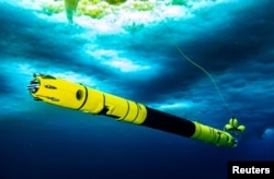 An Icefin is seen in the water as scientists work in the field at the Thwaites Glacier in Antarctica in this undated handout picture obtained by Reuters on February 14, 2023. (Becka Bower/Cornell University/Handout via REUTERS)
