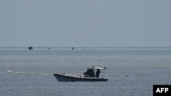 中國海警人員在南海爭議海域乘坐充氣船守在通往中國控制的黃岩島的通道上。(2023年9月22日)