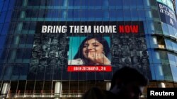 Muškarac prolazi pored zgrade sa slikama talaca otetih u smrtonosnom napadu palestinske islamističke grupe Hamas na Izrael 7. oktobra iz Gaze, u Tel Avivu, 25. marta 2024.