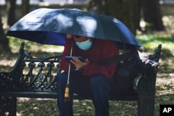 A person shades himself on a hot, sunny day in Chapultepec Park in Mexico City, June 13, 2023.