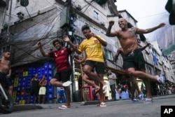 Youth perform a street dance style known as passinho for their social media accounts, in the Rocinha favela of Rio de Janeiro, Brazil, April 11, 2024. (AP Photo/Silvia Izquierdo, File)