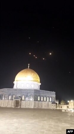 Sebuah tangkapan layar dari video yang diambil pada awal 14 April 2024, menunjukkan jejak roket di langit di atas kompleks Masjid Al-Aqsa di Yerusalem. (Foto: AFP)