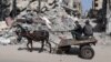 Niños palestinos en un carro tirado por un burro cerca de un edificio destruido por un bombardeo israelí en Ráfah, en el sur de la Franja de Gaza, el 31 de marzo de 2024.