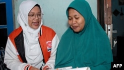 Lingga Permesti (kiri) caleg dari Partai Keadilan Sejahtera (PKS) mengunjungi salah satu rumah warga di Klaten, Jawa Tengah, pada 18 Januari 2024. (Foto: AFP/Agung Nugroho)