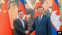 នាយករដ្ឋមន្ត្រីកម្ពុជា លោក ហ៊ុន ម៉ាណែត ចាប់ដៃជាមួយប្រធានាធិបតីចិនលោក Xi Jinping ក្នុងអំឡុងជំនួបមួយ នៅទីក្រុងប៉េកាំង ប្រទេសចិន កាលពីថ្ងៃទី ១៥ ខែកញ្ញា ឆ្នាំ ២០២៣។ (Cambodia's Prime Minister Telegram via AP)