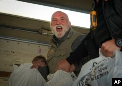 FILE - Jose Andres, a Spanish chef, and founder of World Central Kitchen unloads the humanitarian food packages delivered with WCK's truck in Kherson, Ukraine, on Nov. 15, 2022. (AP Photo/Efrem Lukatsky, File)