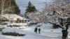 La gente camina por una calle cubierta de nieve en el vecindario de Grant Park en Portland, Oregon, el jueves 23 de febrero de 2023. La ciudad experimentó su segundo día con más nieve registrado. (Foto AP/Drew Callister)