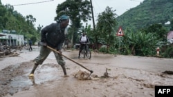 Mwanamume akiondoa vifusi kwenye barabara iliyofurika katika kijiji cha Bupfune kilichopo katika Mkoa wa Magharibi huko Rwanda, tarehe 4 Mei 2023. Picha na Mariam KONE / AFP.