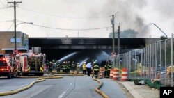 This image provided by the Philadelphia Fire Department shows officials working on the scene following a truck fire on I-95, Sunday, June 11, 2023, in Philadelphia. 