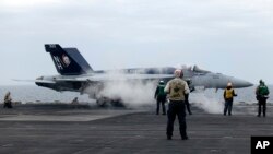 Sebuah jet tempur F-18E bersiap lepas landas dari kapal induk USS Theodore Roosevelt, Kamis 11 April 2024, selama latihan angkatan laut gabungan selama tiga hari oleh AS, Jepang, dan Korea Selatan di Laut Cina Timur. (AP/Mari Yamaguchi)