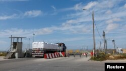 Truk pembawa bantuan kemanusiaan menuju Jalur Gaza ketika mereka meninggalkan area inspeksi di penyeberangan Kerem Shalom, di tengah konflik yang sedang berlangsung antara Israel dan kelompok Islam Palestina Hamas, di Israel selatan, 14 Maret 2024. (REUTERS/Carlos Garcia Rawlins)