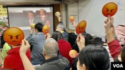 多名參與財政預算案直播會的香港基層市民，高舉”嬲嬲”(不高興)表情紙牌，對俗稱”派糖“的紓困措施大幅”減甜”表達不滿。(美國之音/湯惠芸)