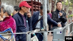 中國大陸旅客在土瓜灣一間酒樓吃完午飯後，聚集在行人路邊抽煙。(美國之音/湯惠芸)