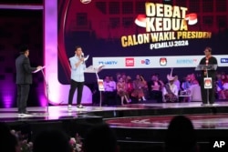 Calon wakil presiden Gibran Rakabuming Raka yang juga putra sulung Presiden Indonesia Joko Widodo (tengah), bersama cawapres lainnya Muhaimin Iskandar (kiri) dan Mahfud MD dalam debat di Jakarta, Jumat, 22 Desember 2023. (AP/Tatan Syuflana)