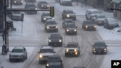Los vehículos se desplazan en el centro de Minneapolis mientras cae nieve, el martes 21 de febrero de 2023.