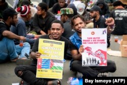 Dua orang pria Papua menunjukkan poster bertuiiskan "kemerdekaan adalah hak segala bangsa" dalam demonstrasi menuntut referendum kemerdekaan Provinsi Papua di Jakarta, 1 Desember2023. (Foto: Bay Ismoyo/AFP)
