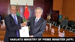 瓦努阿图总理办公室2024年7月2日发布图片显示，瓦努阿图总理萨尔瓦伊（左）与中国全国政协副主席胡春华在新总统府的正式移交给瓦努阿图政府的仪式上握手。