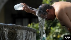 A man cools himself down with water from a water fountain during one of the hottest days of the third heat wave in Guadalajara, Jalisco state, Mexico, on June 12, 2023. 
