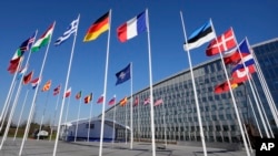 Un asta de bandera vacía se encuentra entre las banderas nacionales de Francia y Estonia frente a la sede de la OTAN en Bruselas, el lunes 3 de abril de 2023.