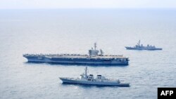 ภาพจากกระทรวงกลาโหมเกาหลีใต้เเสดงให้เห็นว่าเรือบรรทุกเครื่องบิน ยูเอสเอส ธีโอดอร์รูสเวลต์ของสหรัฐฯ กำลังอยู่ในทะเลโดยมีเรือพิฆาตเกาหลีใต้ และเรือรบของญี่ปุ่นขนาบข้างในการซ้อมรบบริเวณน่านน้ำสากลทางใต้ของเกาะเจจู (Photo by Handout / South Korean Defence Ministry / AFP) / 