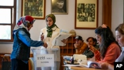 A woman votes at a polling station in Istanbul, March 31, 2024.