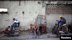 Los lustradores de zapatos asisten a los clientes a lo largo de una calle en Santiago de Cuba. Una imagen tomada el 19 de septiembre de 2015. El gobierno cubano anunció el 4 de abril de 2024 sobre la distribución de alimentos en la provincia donde hubo protestas.