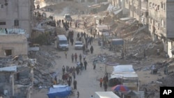 Palestinians ecin mes rrënojave pas një sulmi të forcave izraelite në Khan Yunis (15 maj 2024)