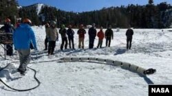 Team members from JPL test a snake robot called EELS at a ski resort in the Southern California mountains in February 2023. (Photo Credit: NASA/JPL-Caltech)