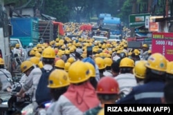 Karyawan perusahaan nikel PT Indonesia Morowali Industrial Park (IMIP) tampak bersiap akan pulang usai bekerja di Konawe, 14 April 2023. (Foto: RIZA SALMAN/AFP)