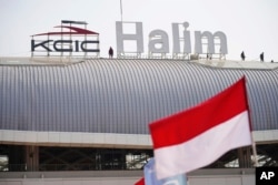 Para pekerja berdiri di puncak Stasiun Halim saat pembangunannya menjelang uji operasional kereta cepat Jakarta-Bandung pada September, di Jakarta, 12 Agustus 2023. (Foto: AP)